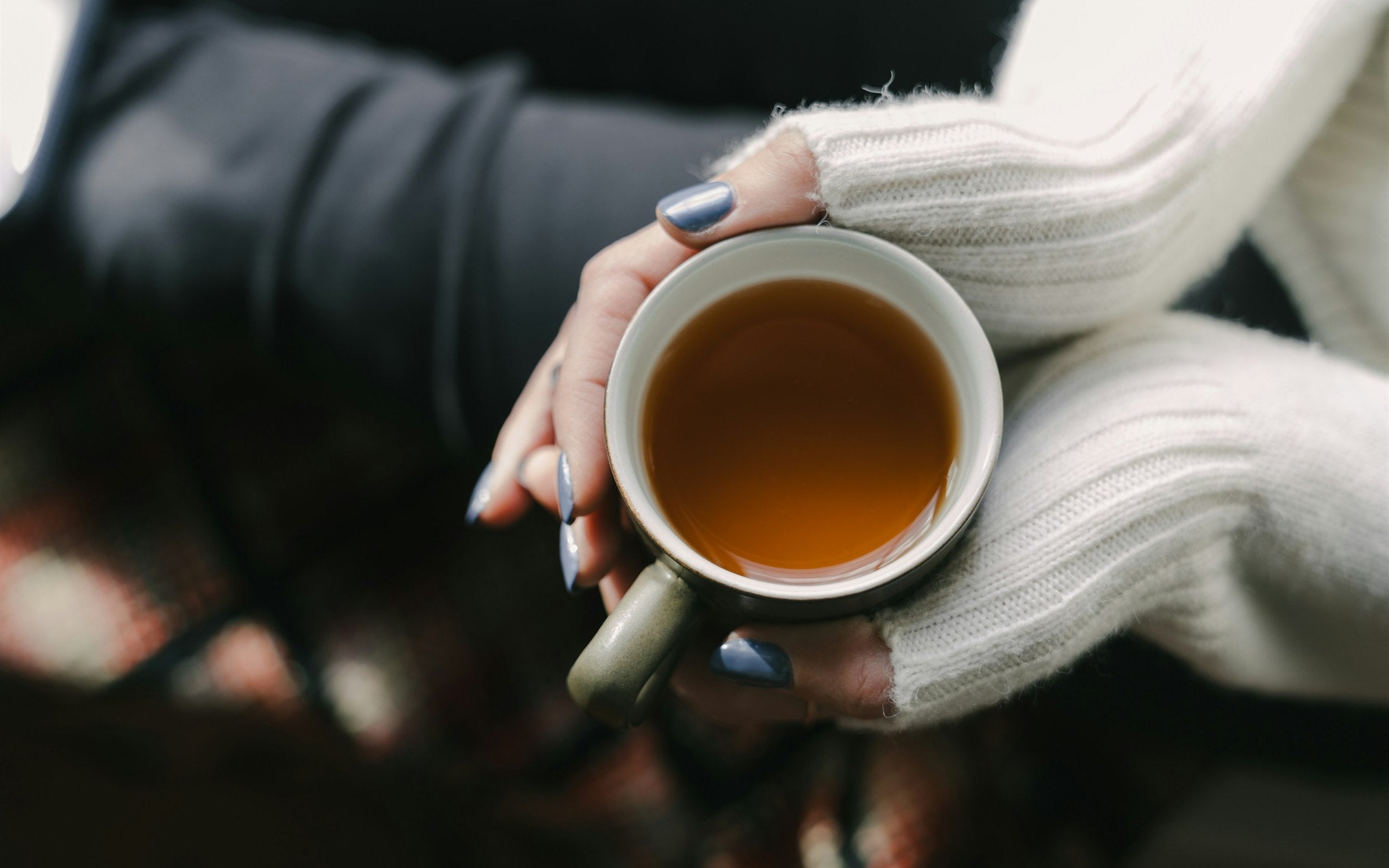 Mujer sosteniendo taza de te en luz dorada matinal